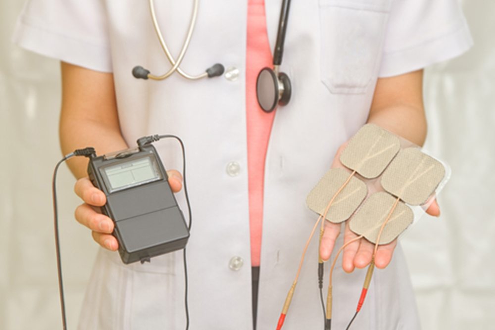 Doctor's hold Medical Tens Unit for pain therapy